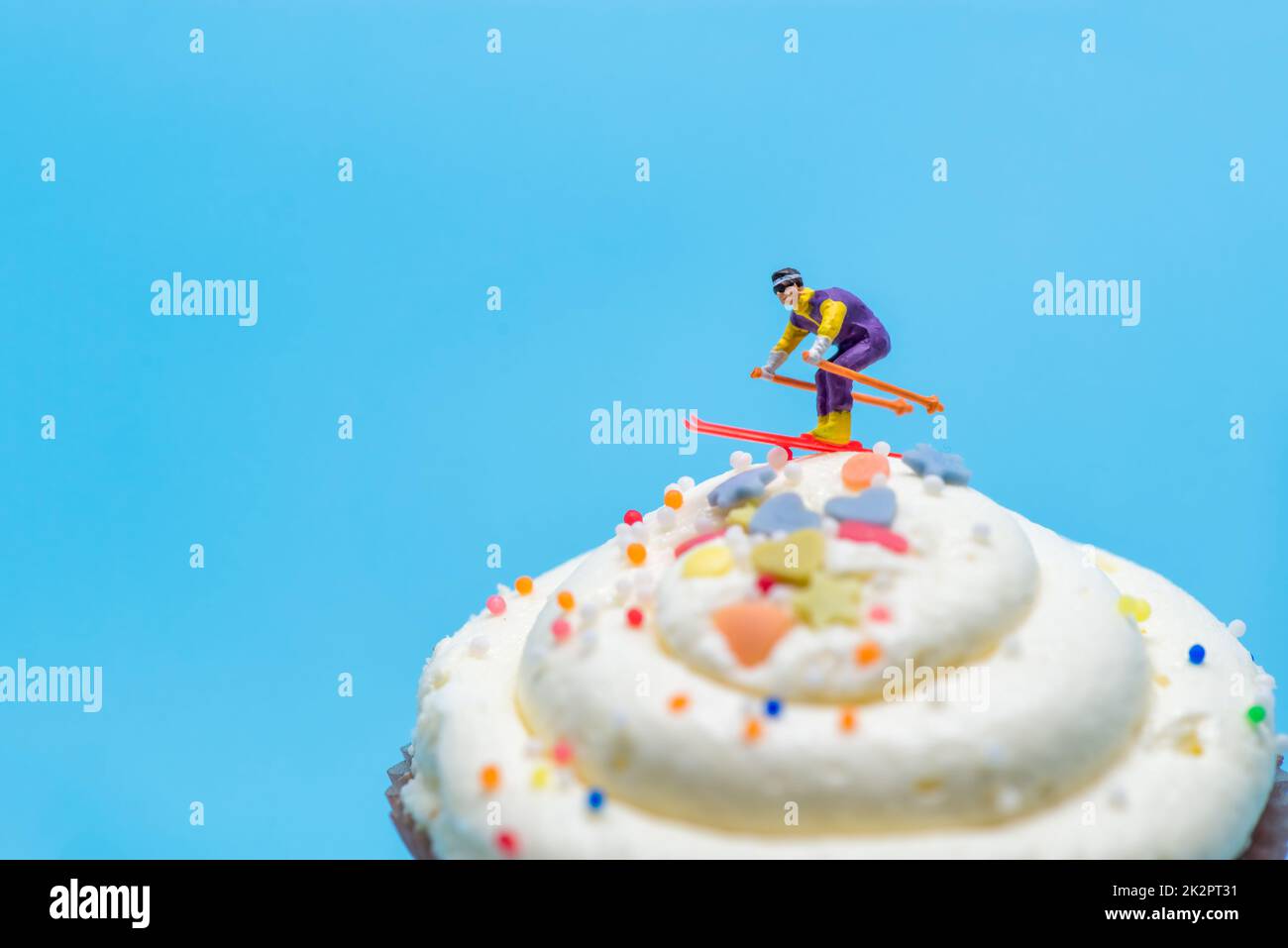 Skieur miniature skier en bas d'un cupcake Banque D'Images