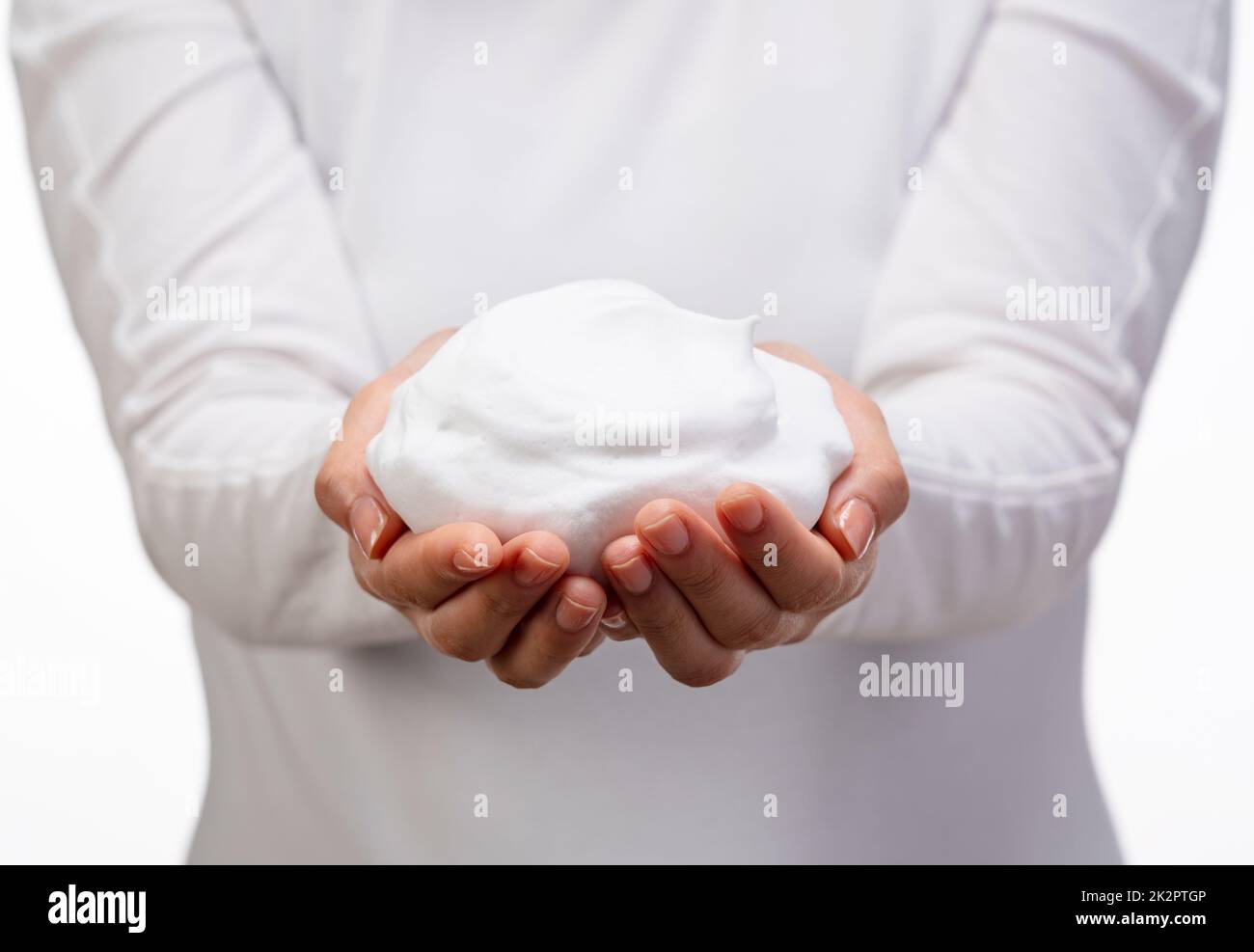 Femme tenant des bulles de savon sur fond blanc. Banque D'Images