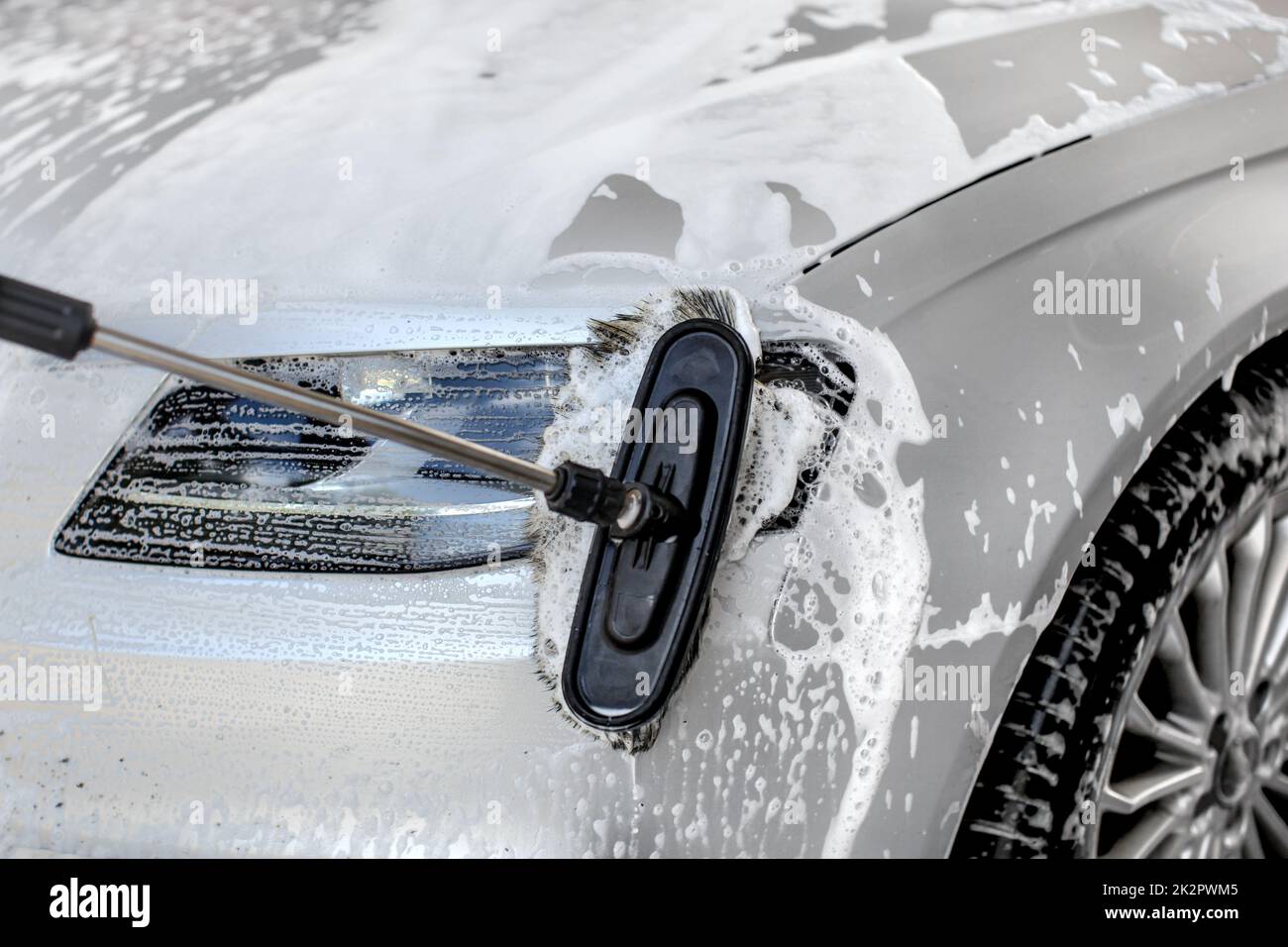 Détail sur l'argent phare de voiture lavés à carwash manuel, brosses de nettoyage du verre. Banque D'Images