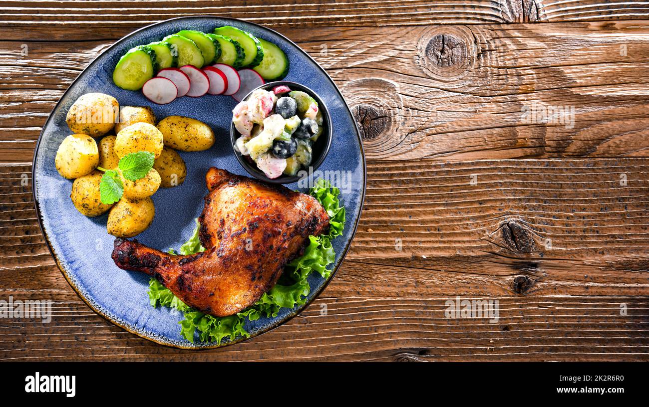 Cuisse de poulet cuite avec pommes de terre et salades de légumes Banque D'Images