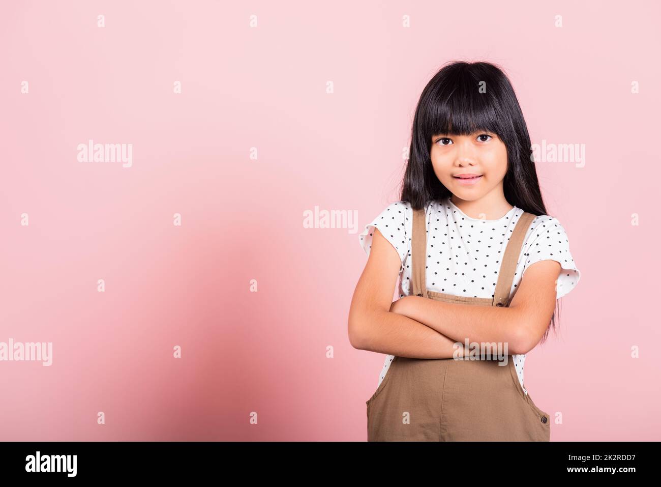 Petit enfant asiatique de 10 ans souriant avec les bras croisés Banque D'Images