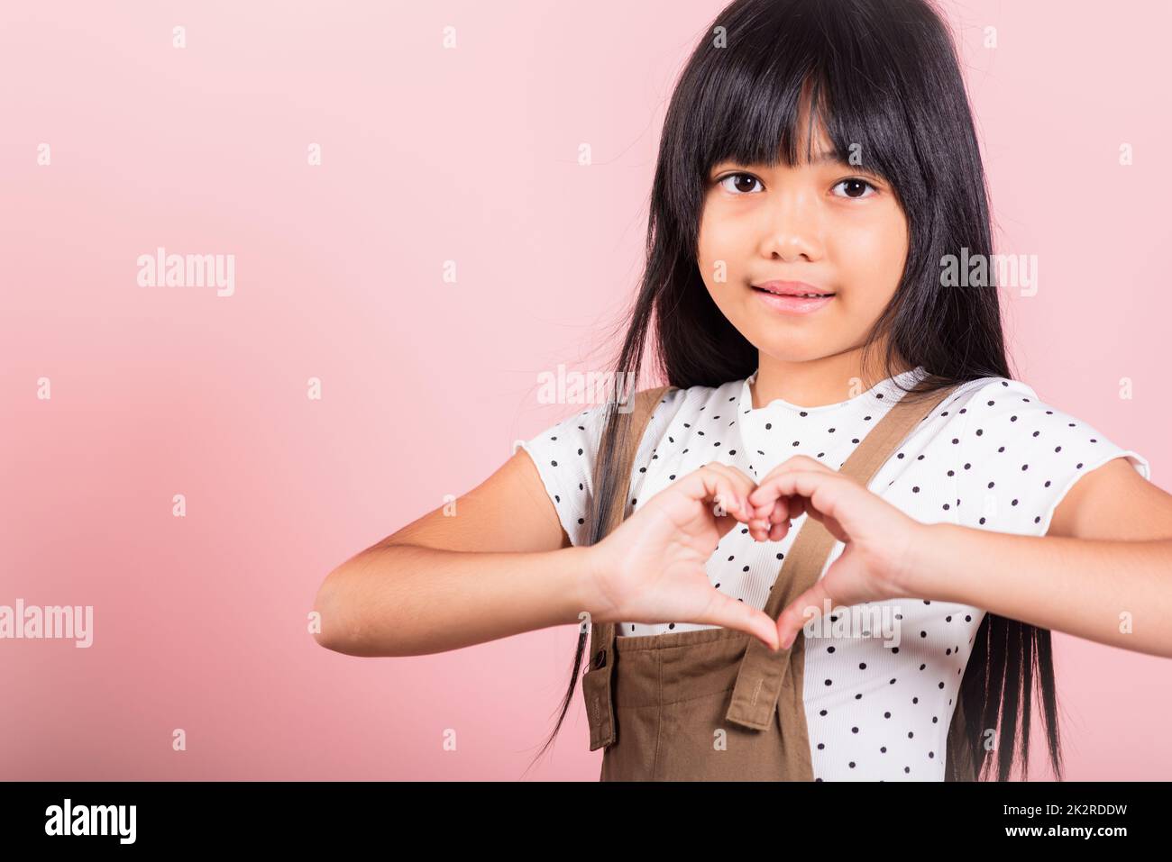 Petit enfant asiatique de 10 ans montrant un cœur Banque D'Images