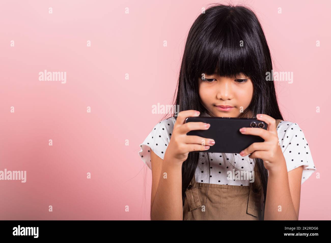 Enfant asiatique 10 ans en train d'utiliser un téléphone mobile pour les réseaux sociaux Banque D'Images