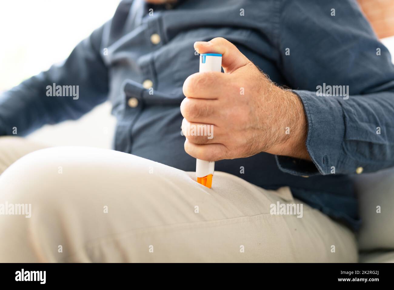 Homme injectant de l'épinéphrine à l'aide d'une seringue à auto-injecteur Banque D'Images
