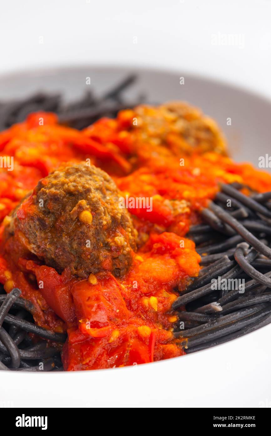 spaghetti noirs avec sauce tomate et boulettes de viande Banque D'Images