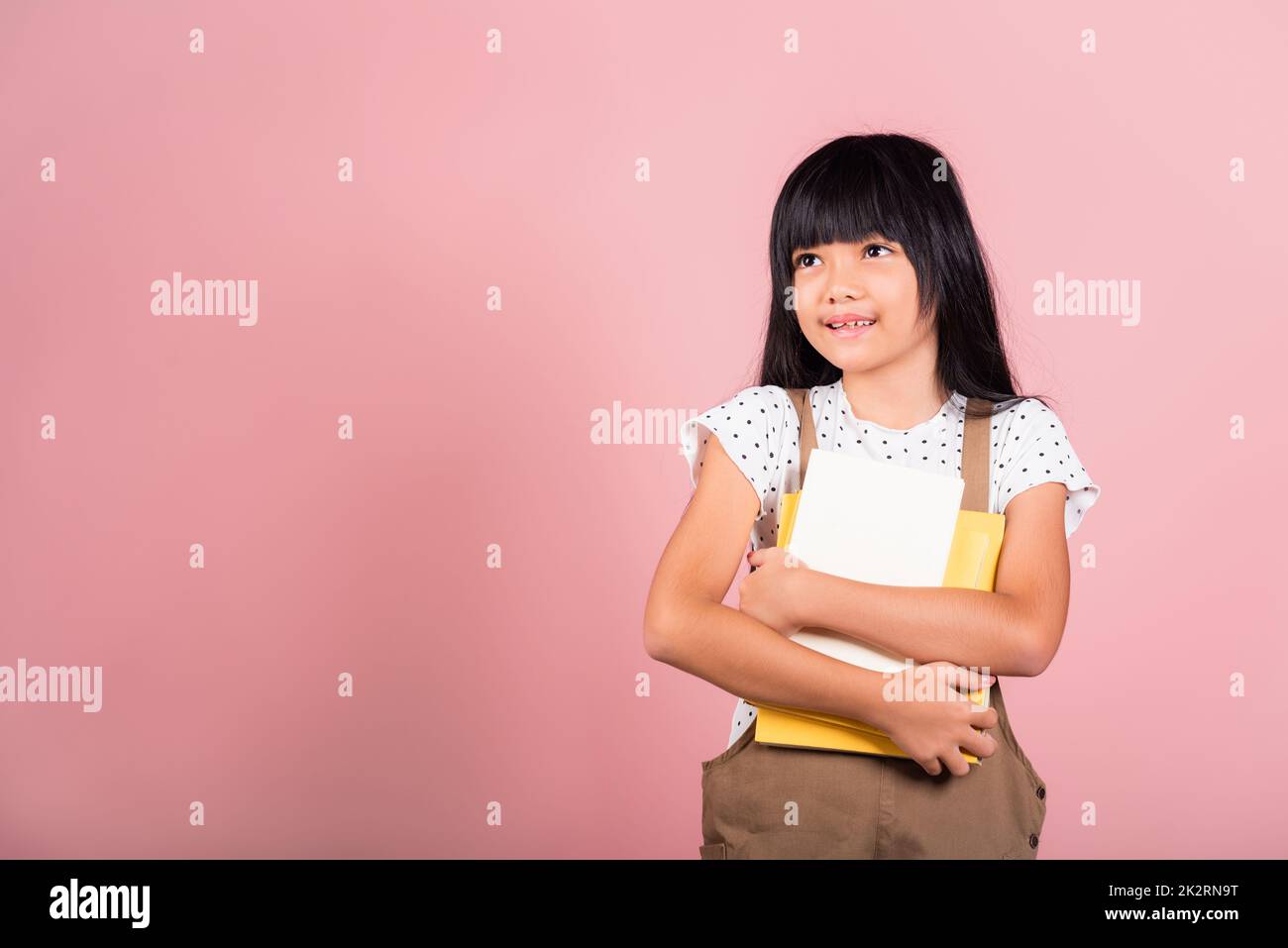 Petit enfant asiatique de 10 ans tenant un livre pour aller à l'école Banque D'Images