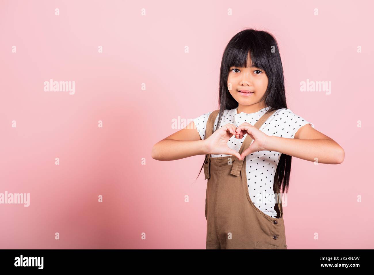 Petit enfant asiatique de 10 ans montrant un cœur Banque D'Images