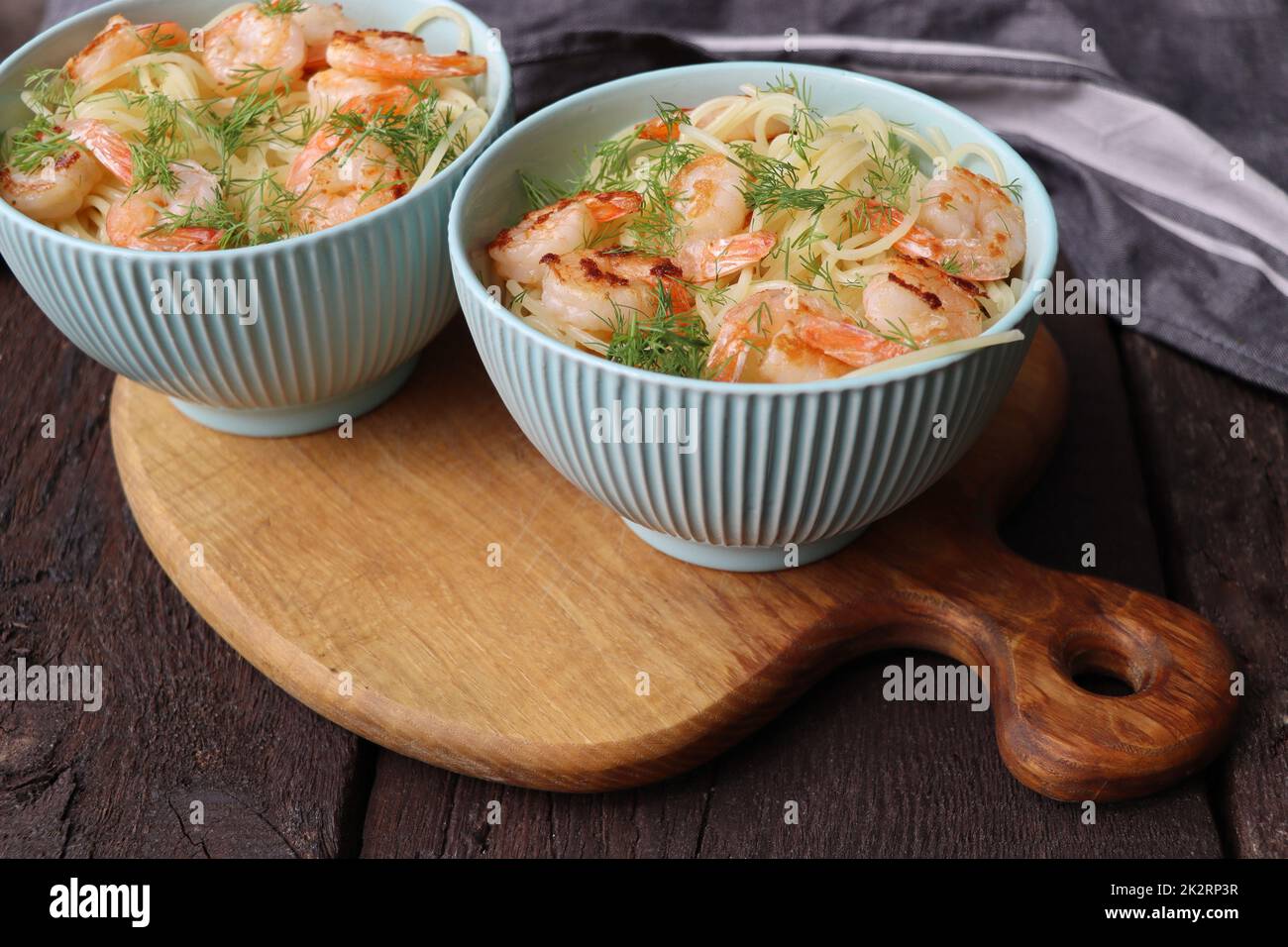 Deux bols de délicieuses crevettes alfredo avec sauce à l'ail et à la crème sur des pâtes sur une table rustique en bois Banque D'Images