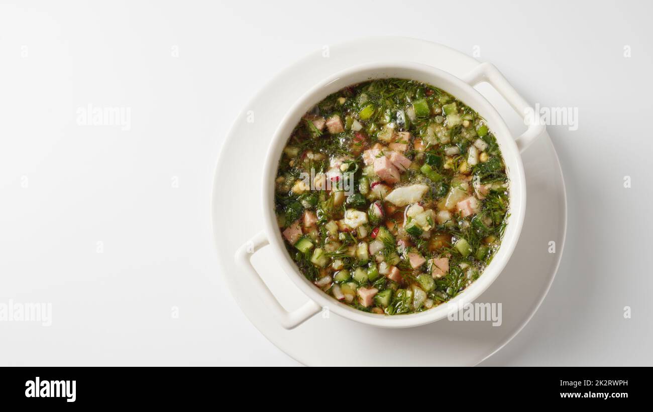 Okroshka, soupe froide légère d'été avec concombre, radis, œufs et aneth avec crème aigre et oignon vert Banque D'Images