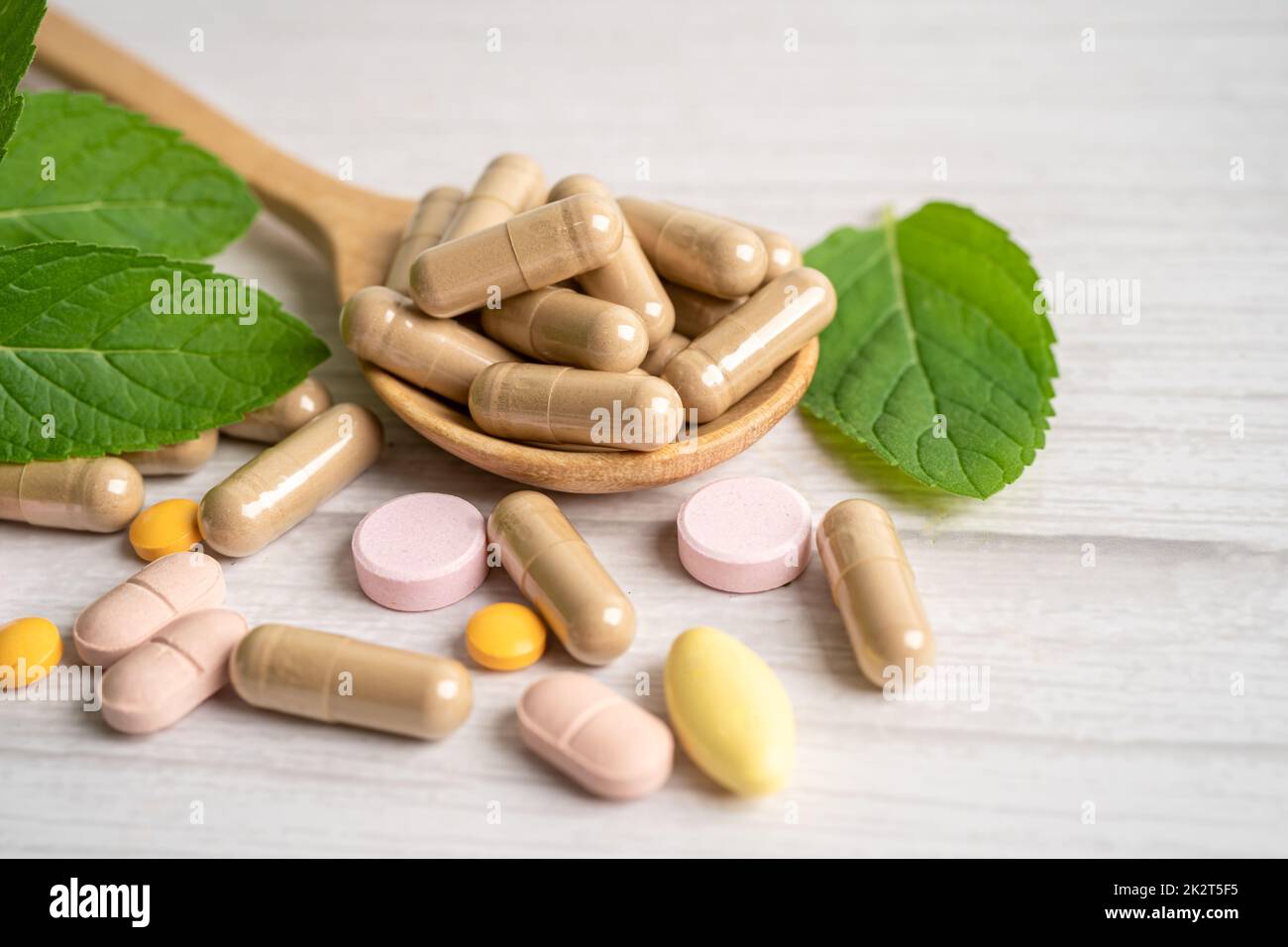 Médecine alternative capsule organique à base de plantes avec vitamine E oméga 3 huile de poisson, minéral, médicament avec des herbes feuilles suppléments naturels pour une bonne vie saine. Banque D'Images