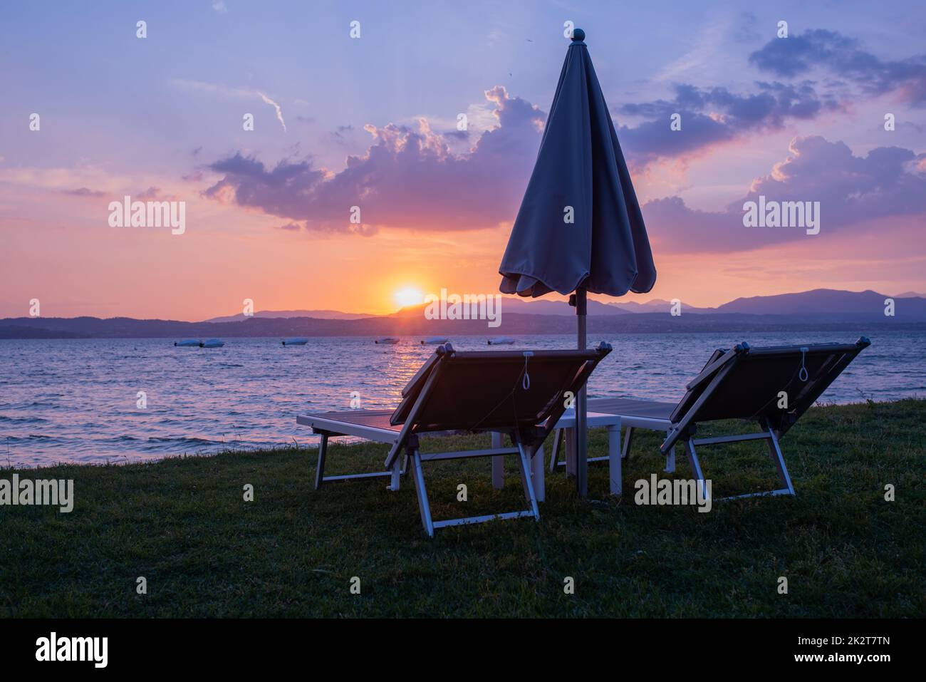 Chaises longues avec parasol sur le lac de garde Banque D'Images