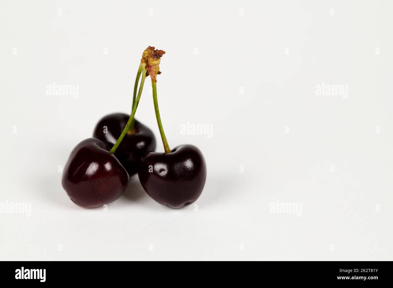 Trois cerises sur blanc Banque D'Images