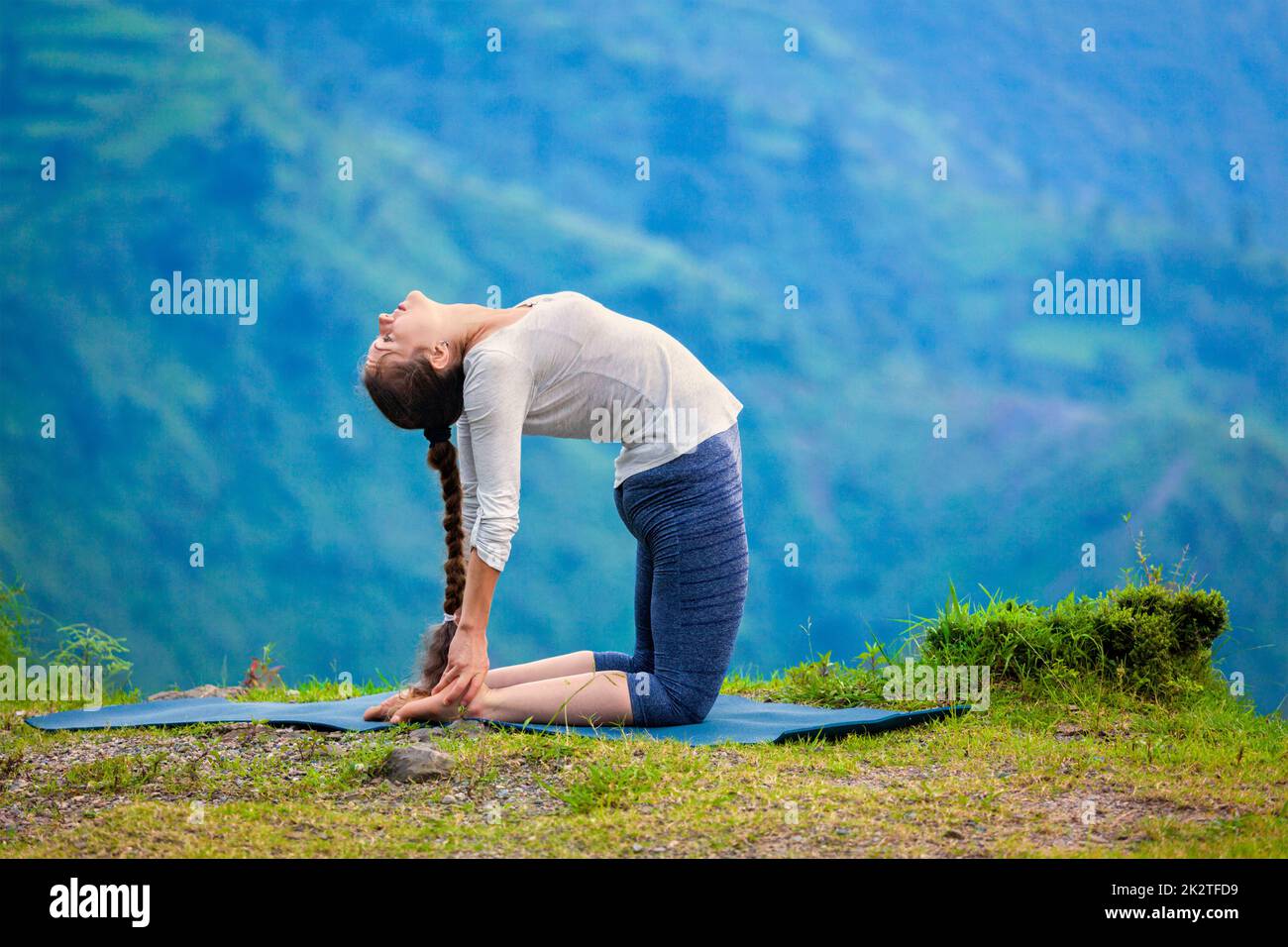 Woman doing yoga asana Ustrasana camel posent à l'extérieur Banque D'Images