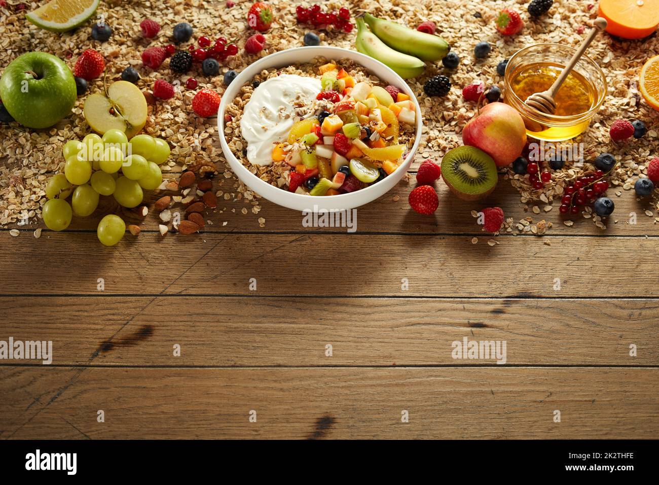 Bol de petit déjeuner appétissant avec fruits et baies sur table en bois Banque D'Images