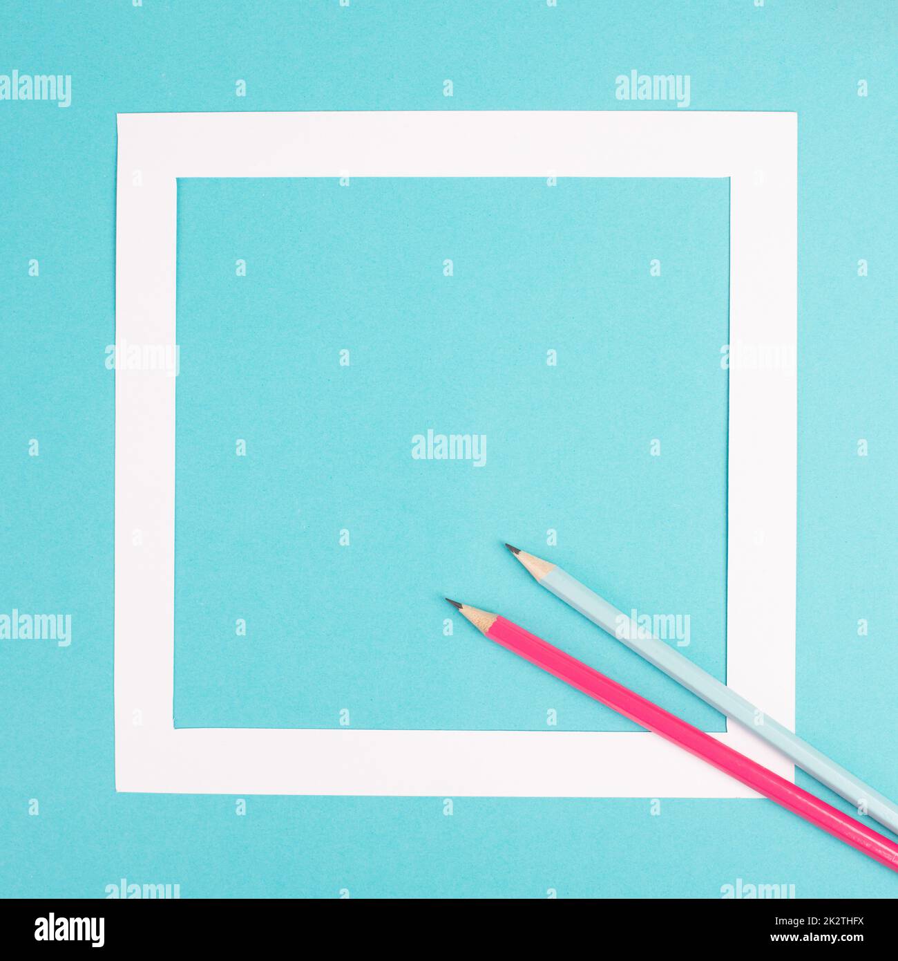 Crayons sur fond de papier bleu, cadre blanc avec espace de copie pour le texte, minimalisme, concept créatif et commercial, couleur pastel Banque D'Images