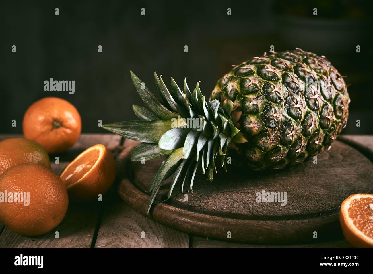 Ananas et oranges sur table en bois Banque D'Images