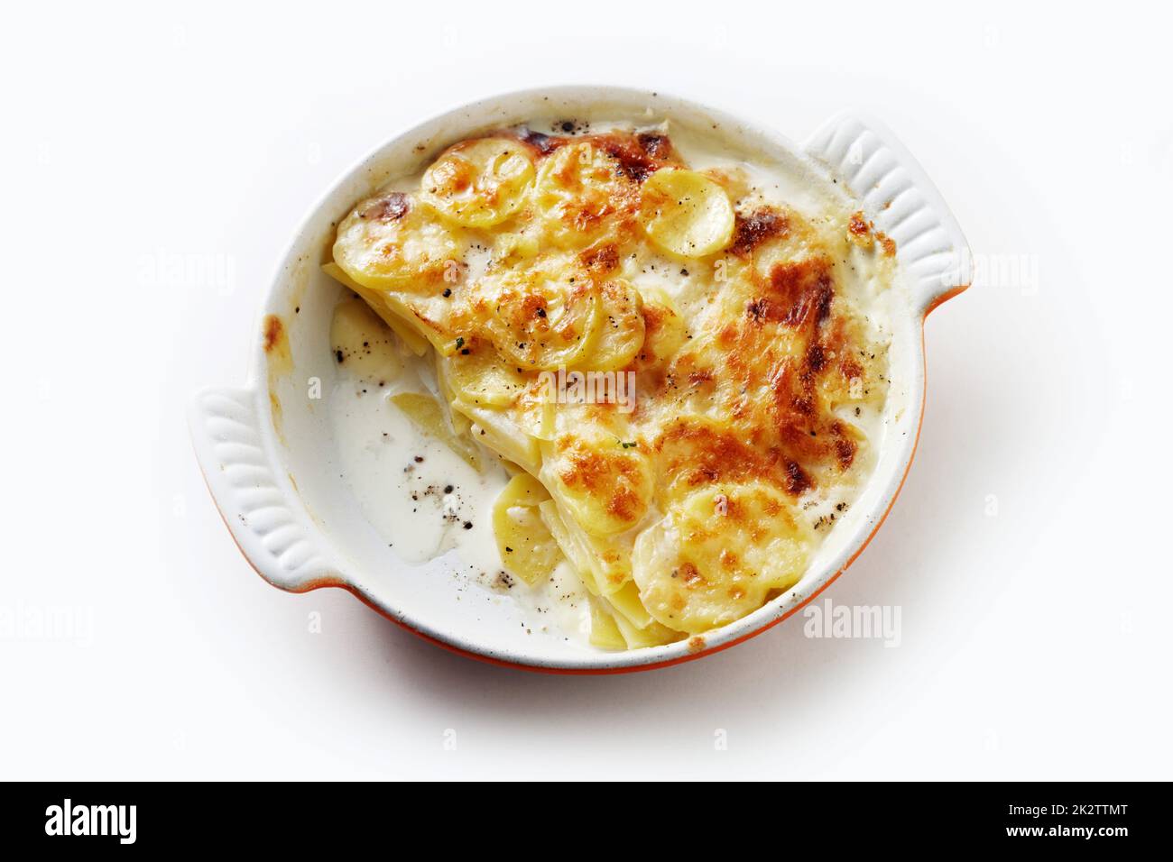 Délicieux plat de cuisson avec pomme de terre et crème dans une casserole en céramique sur la table Banque D'Images
