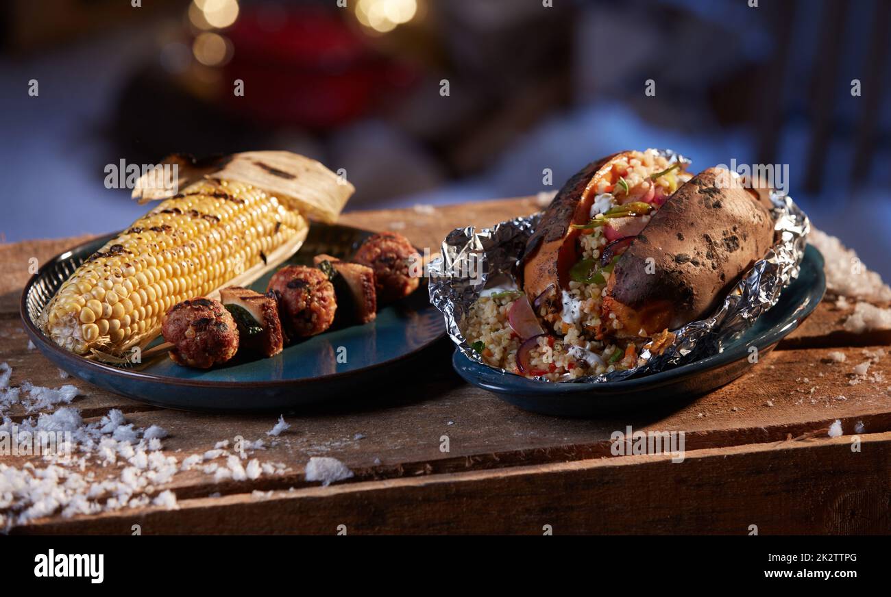 Légumes grillés et boulettes de viande servis sur une table en bois Banque D'Images