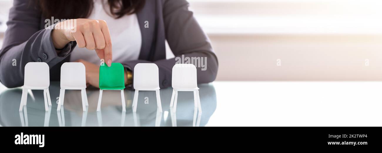 Businesswoman fauteuil vert Choisir parmi les chaises blanches dans une rangée Banque D'Images