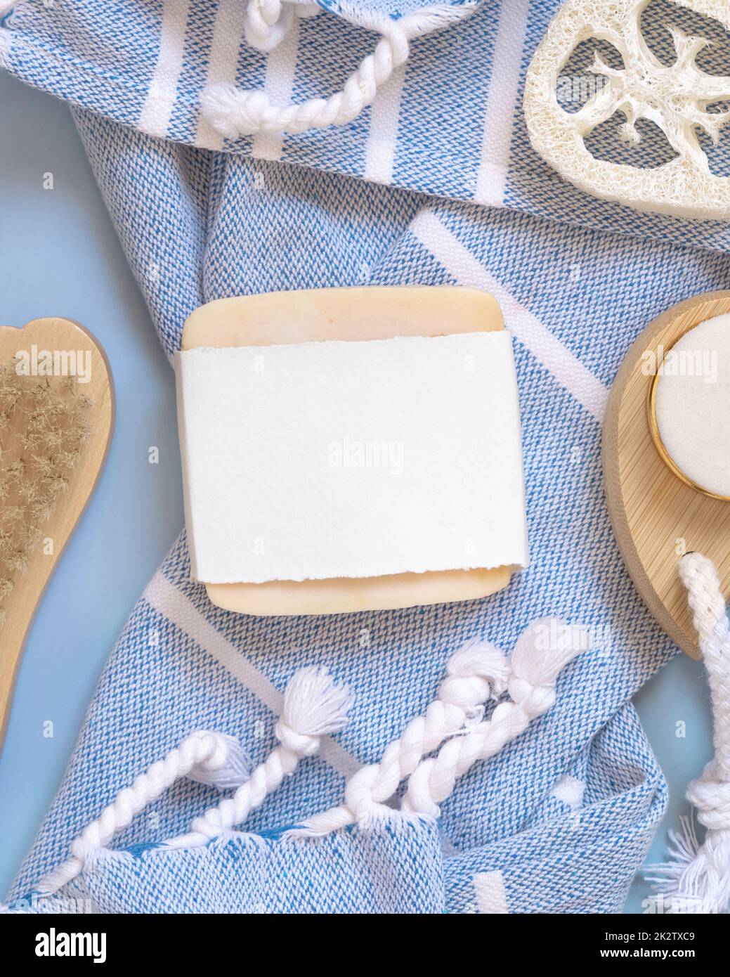 Porte-savon fait main sur serviette de bain bleue vue de dessus, maquette d'emballage. Produits de beauté naturels Banque D'Images