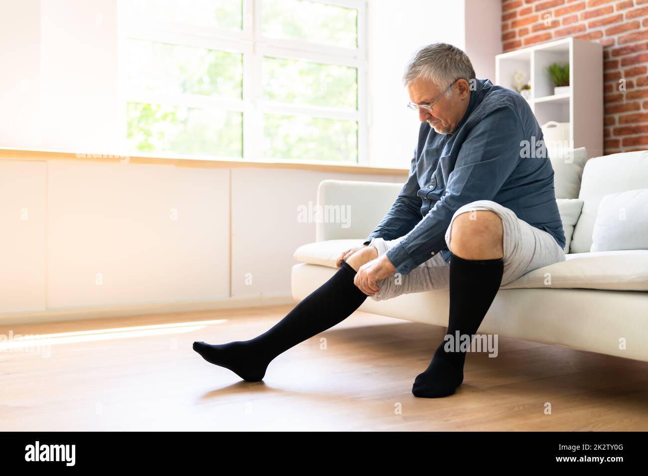 Homme mettant des bas de compression médicale Banque D'Images