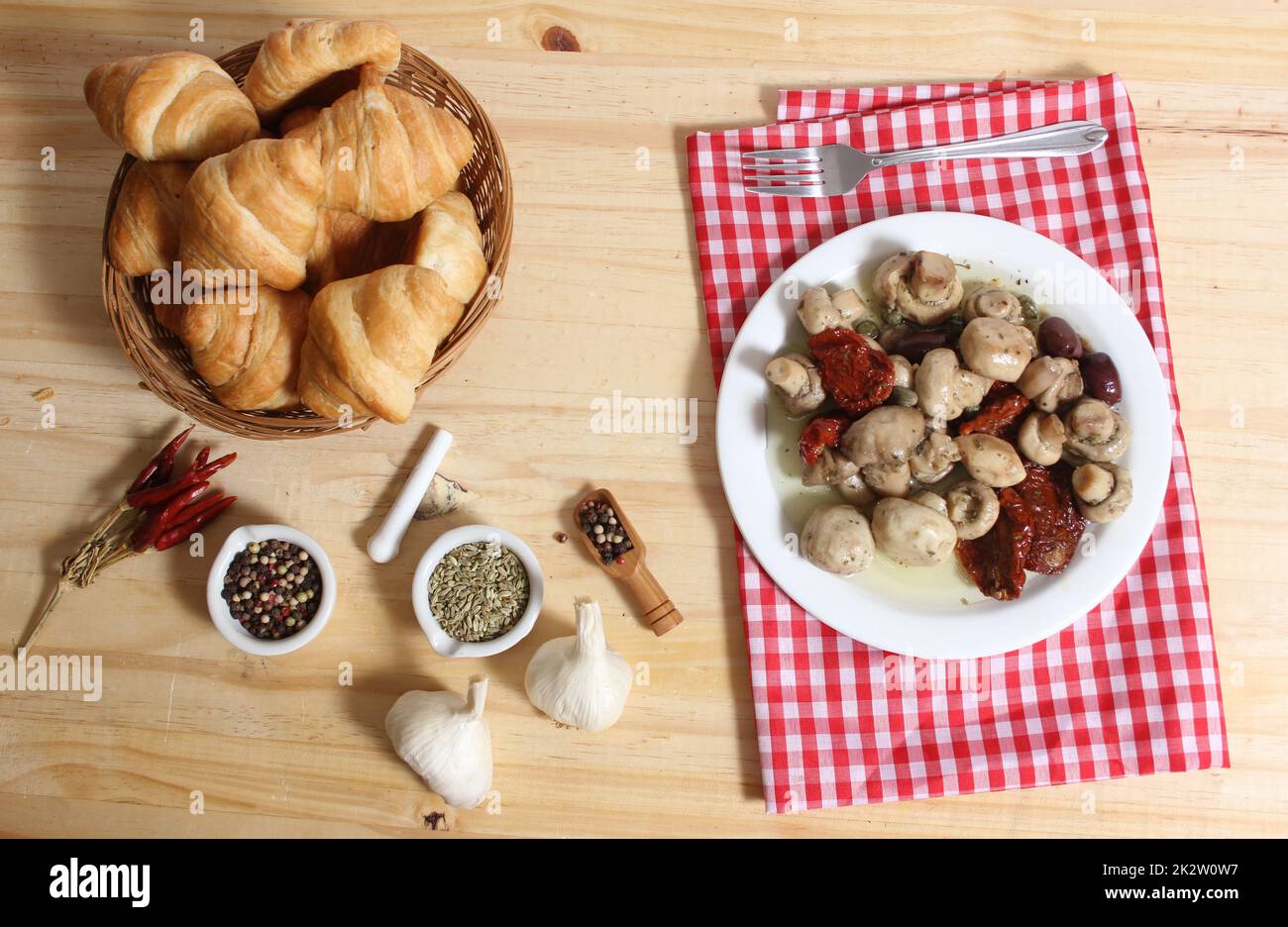 Champignons, tomates séchées au soleil, olives et câpres en huile d'olive sur table rustique Banque D'Images