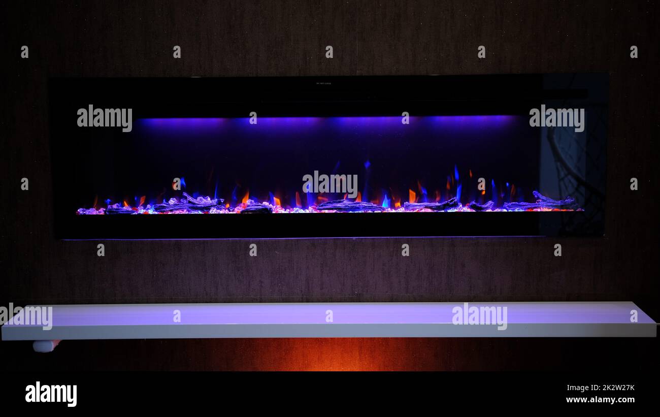 vue sur cheminée électrique avec flamme artificielle étincelante, décor intérieur, flamme orange et bleue Banque D'Images