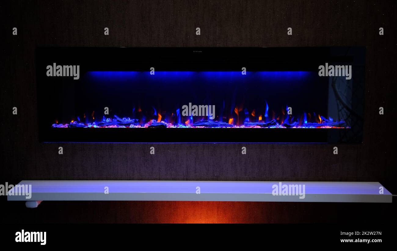 vue sur cheminée électrique avec flamme artificielle étincelante, décor intérieur, flamme orange et bleue Banque D'Images