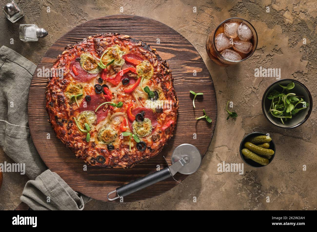 Pizza américaine avec pepperoni, mozzarella, poivron, sauce aux olives et aux tomates. Pizza sur une table en bois Banque D'Images