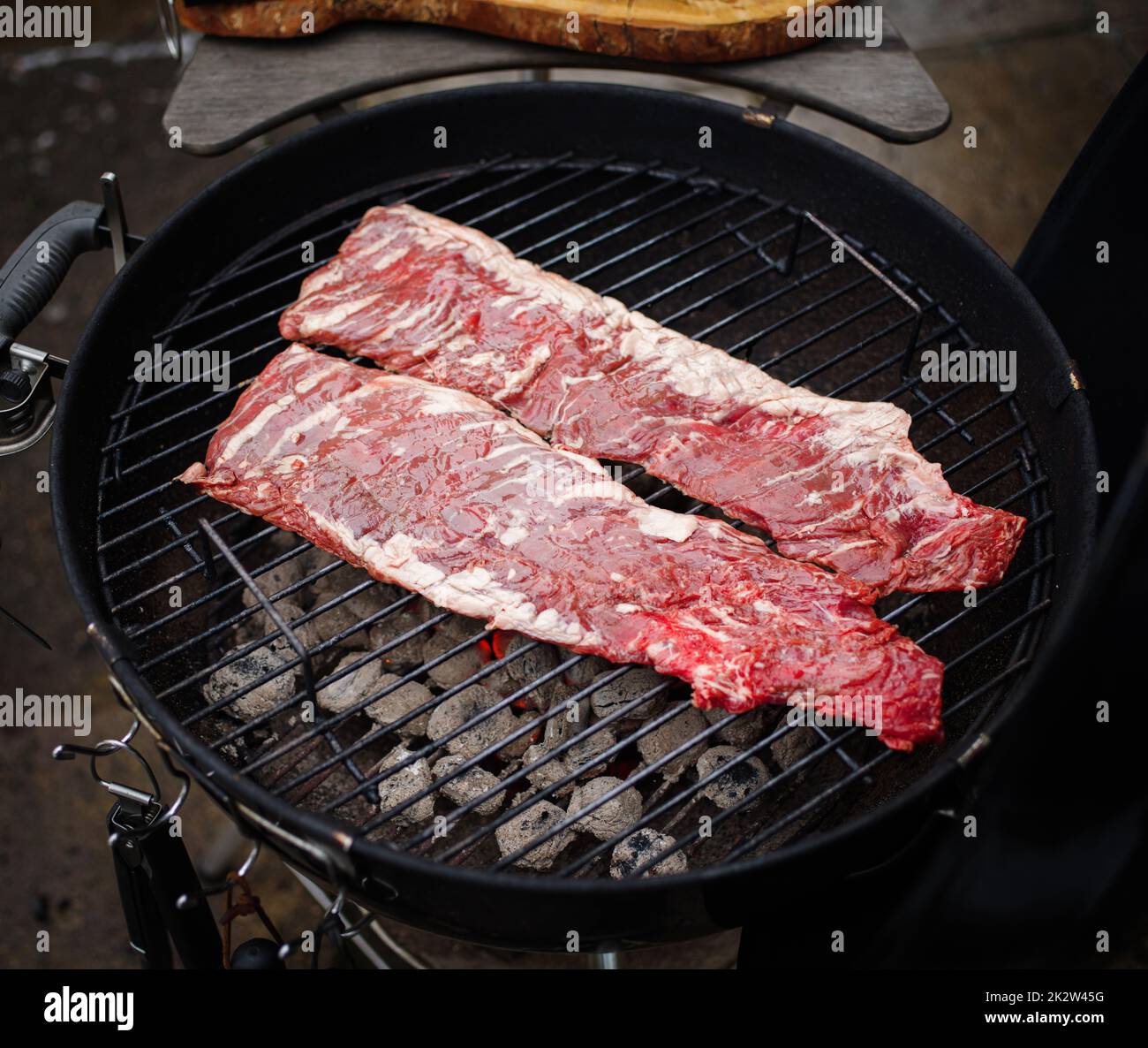 Le steak de bœuf tendre ou onglet est suspendu sur le gril. Griller de la viande. BARBECUE Banque D'Images Le steak de bœuf tendre ou onglet est suspendu sur le gril. Griller de la viande. BARBECUE Banque D'Images