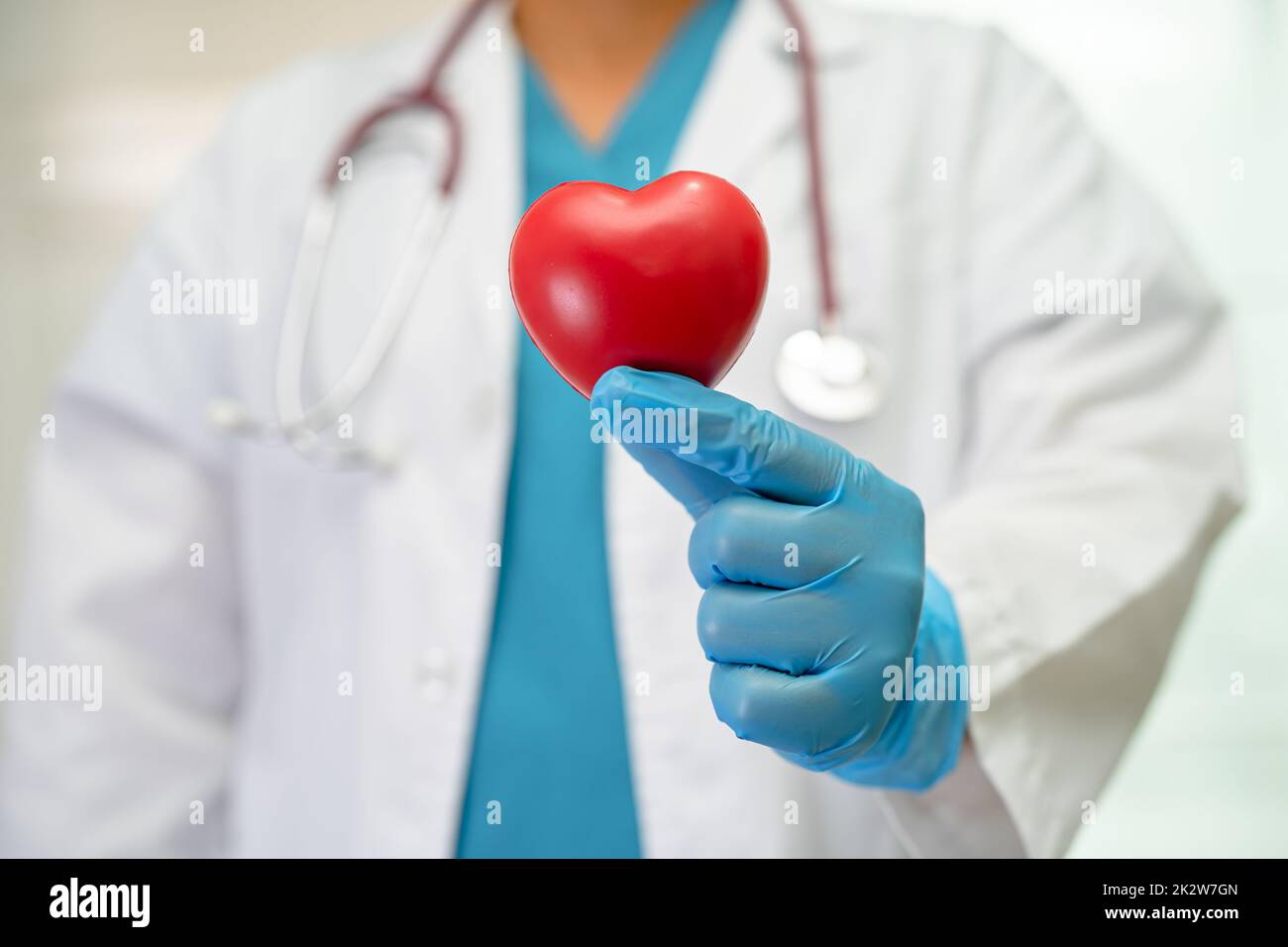 Médecin tenant un cœur rouge dans la salle d'hôpital, sain concept médical fort. Banque D'Images