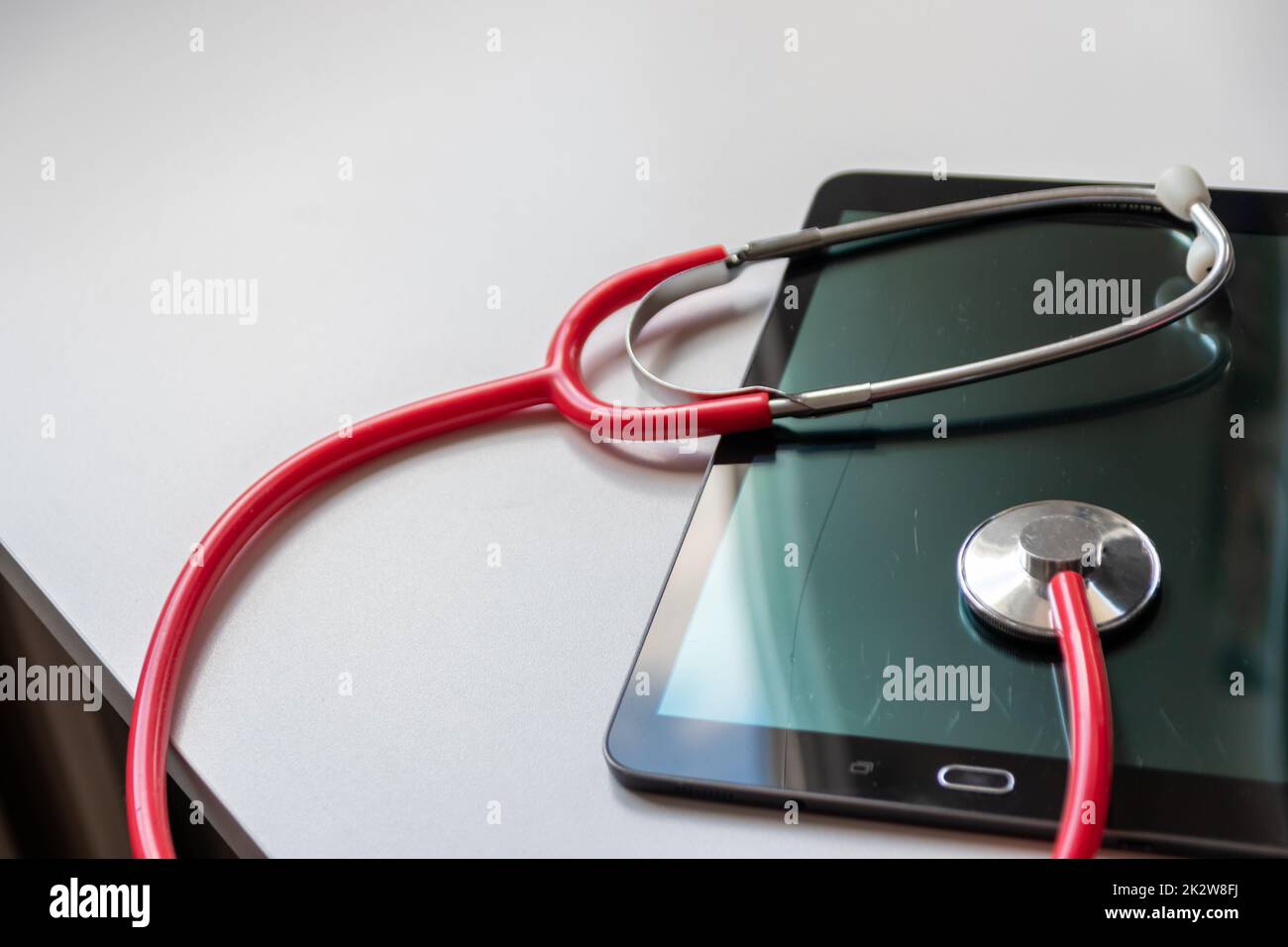 Le stéthoscope rouge sur tablette noire affiche les dossiers de santé et les dossiers médicaux numériques sur la sécurité des données dans le cloud pour les médecins numériques et le diagnostic de récupération numérique grâce à des équipements et technologies modernes Banque D'Images