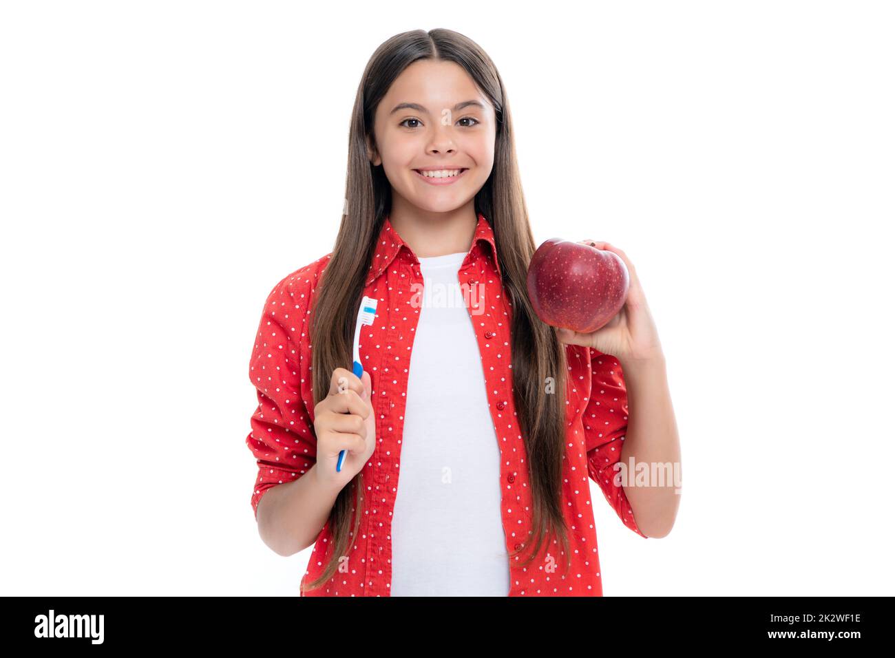 La brosse à dents de maintien de fille d'adolescence, le bonheur d'enfance, la routine du matin. Brosser les dents, soins dentaires et soins buccaux. Enfant brosse ses dents. Vitamines de pomme pour Banque D'Images