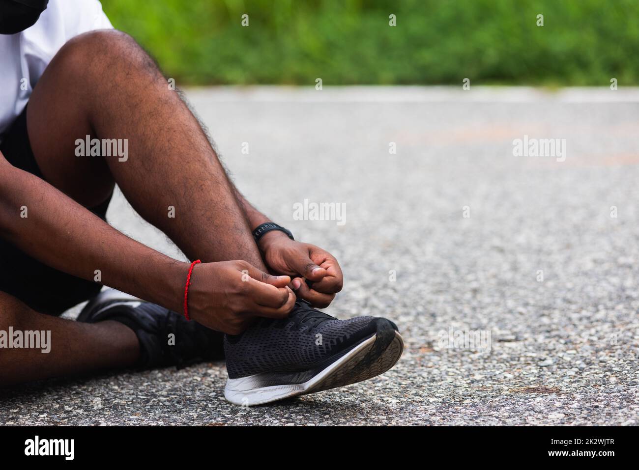 coureur noir homme assis cordonnet essayer les chaussures de course à pied Banque D'Images