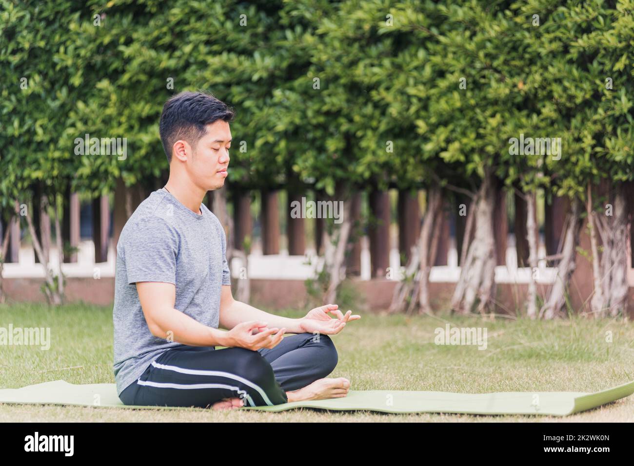 jeune homme faisant du yoga à l'extérieur dans méditer lotus pose Banque D'Images