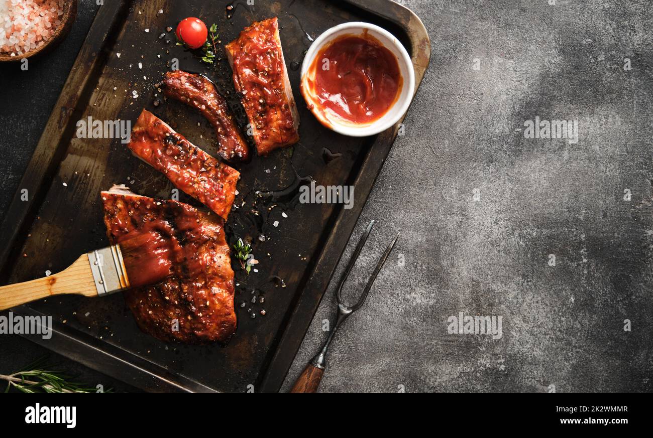 De délicieuses côtes grillées assaisonnées d'une sauce épicée et servies sur une poêle à repasser. Banque D'Images