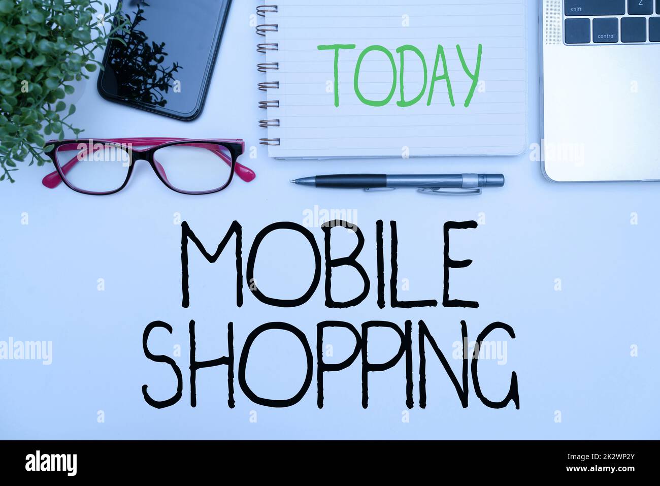 Légende du texte présentant Mobile Shopping. Photo conceptuelle achat et vente de biens et de services par le biais de fournitures de bureau mobiles avec clavier et lunettes et tasse à café pour le travail Banque D'Images