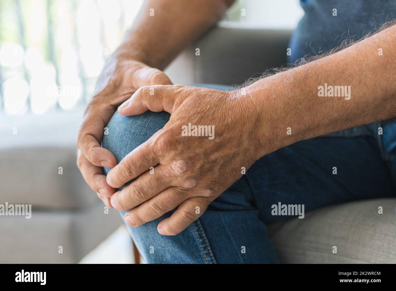 Senior tenant son genou douloureux Banque D'Images