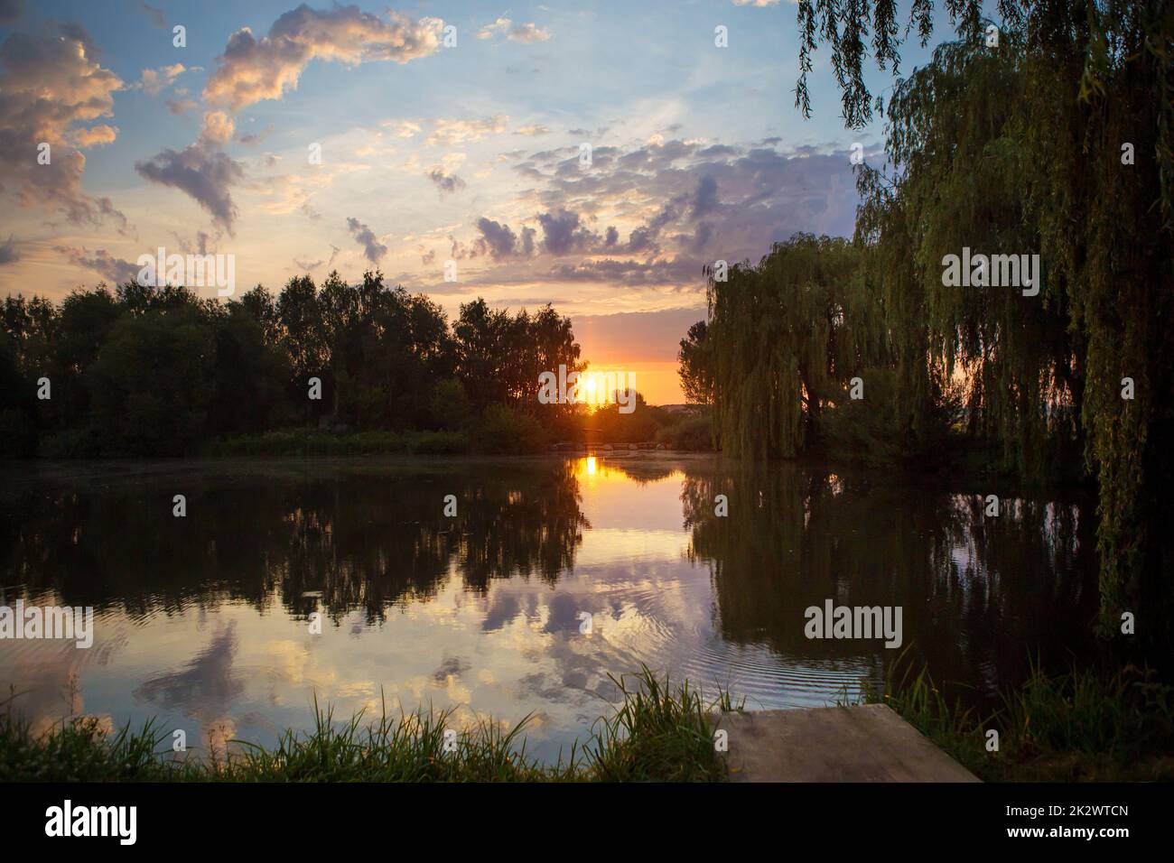Superbe coucher de soleil sur un petit lac de pêche. Banque D'Images