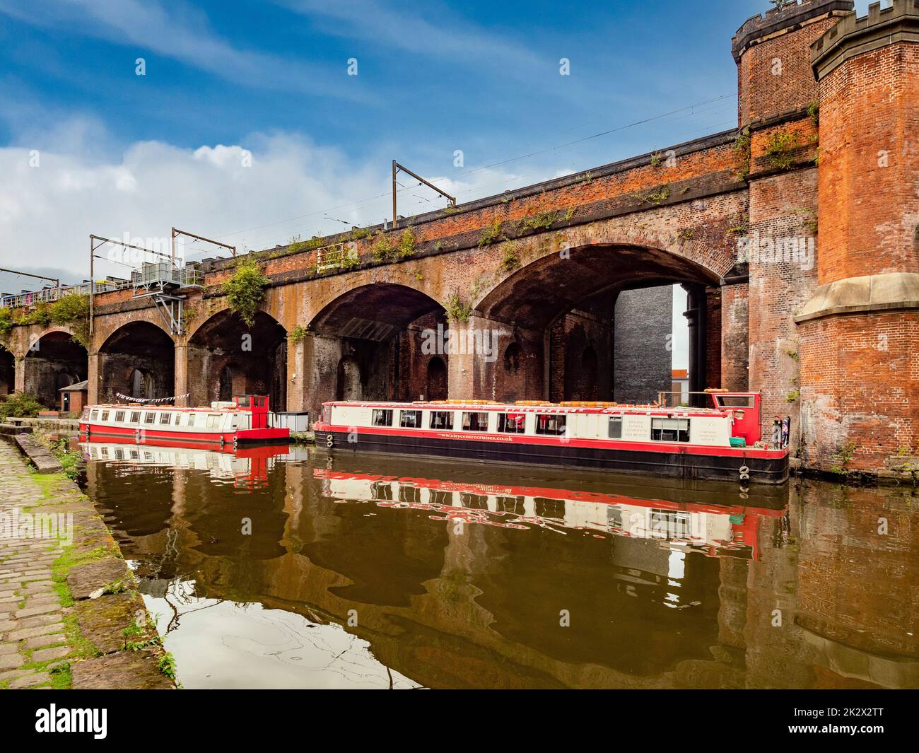 Des bateaux de croisière sur le canal amarrés le long du viaduc de Bridgewater dans la région de Castlefield à Manchester. ROYAUME-UNI Banque D'Images