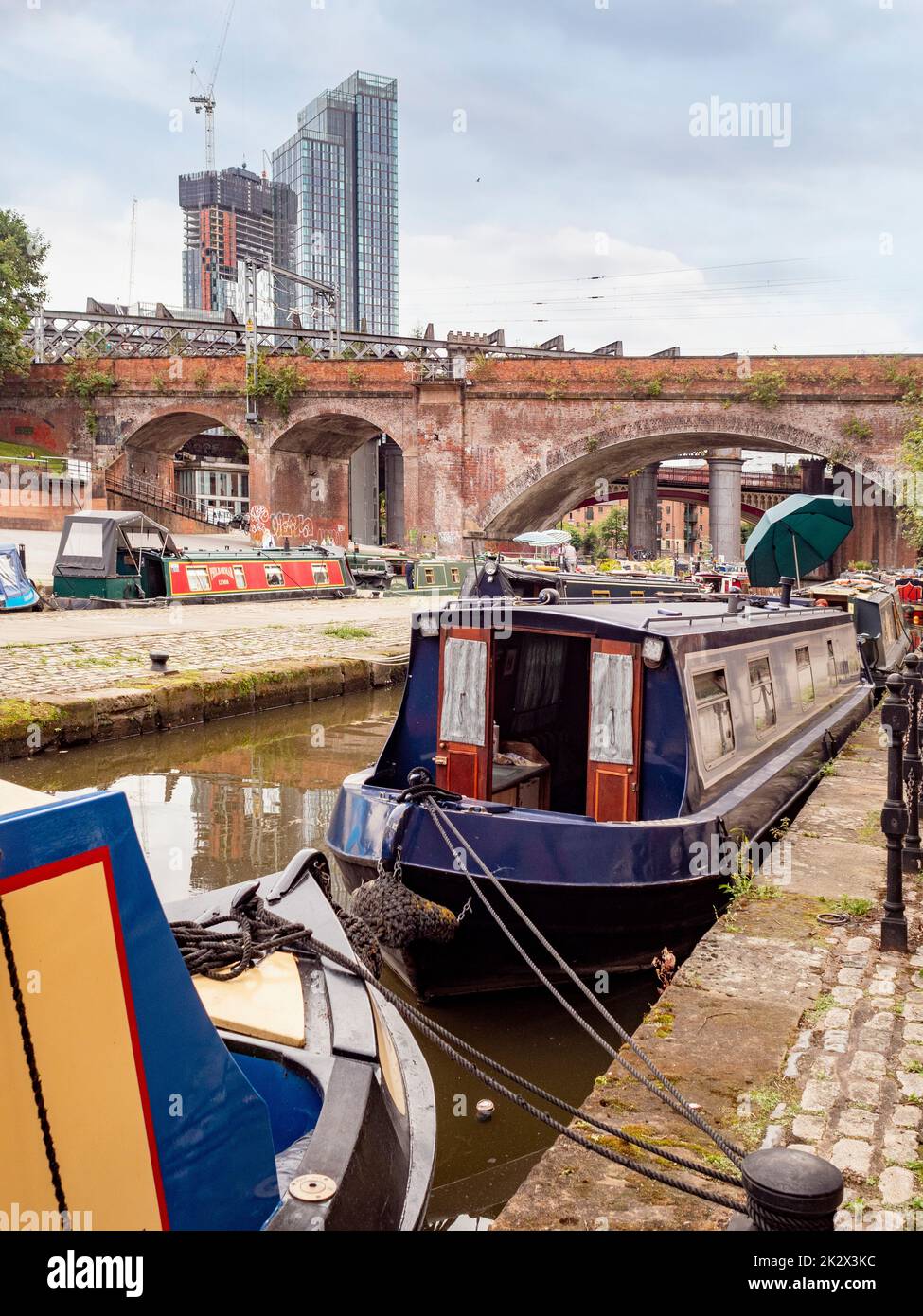 Des bateaux étroits amarrés dans le bras Staffordshire du canal Bridgewater avec Elizabeth Tower au loin. Manchester, Royaume-Uni. Banque D'Images