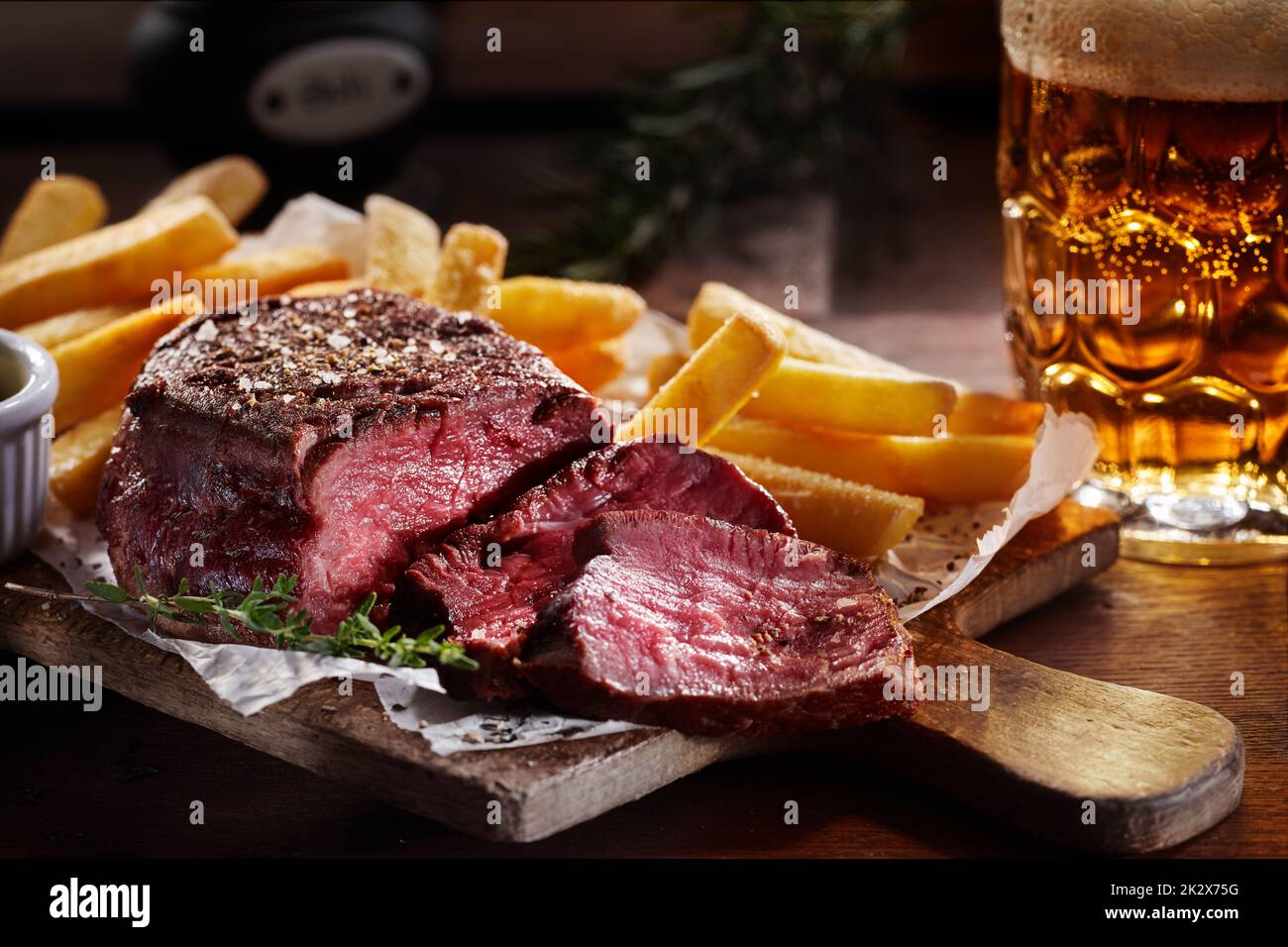 De savoureuses tranches de steak de bœuf avec des frites et de la bière