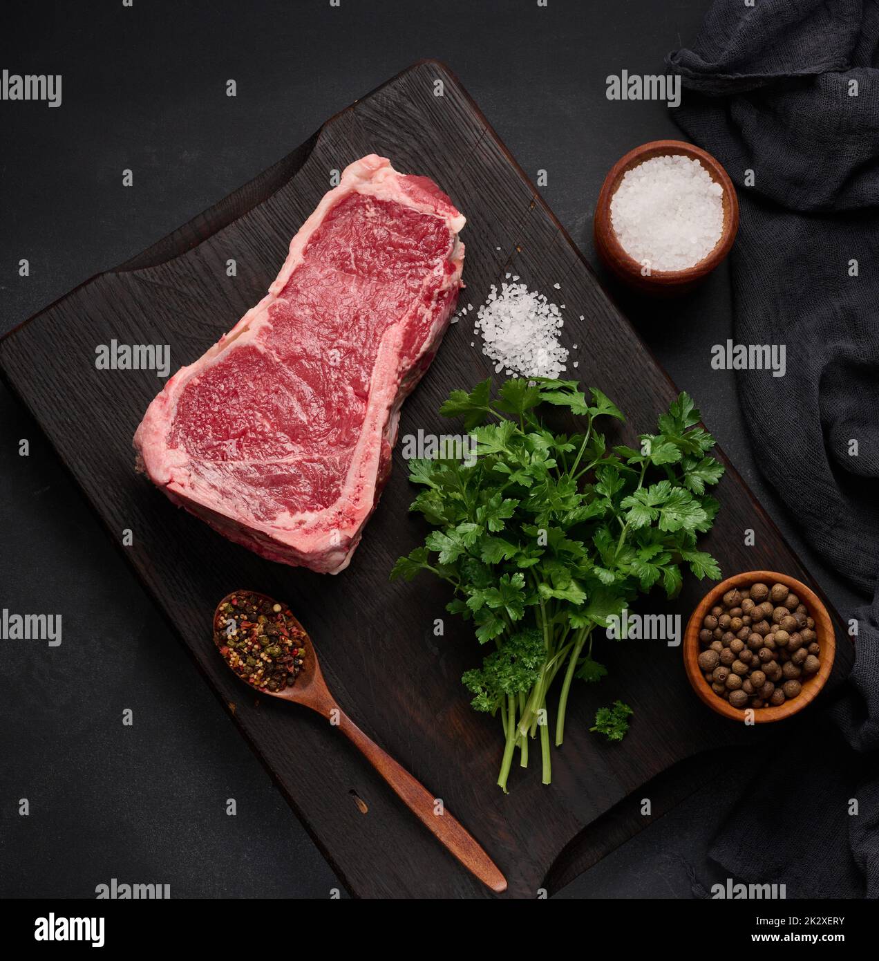 Morceau de viande de bœuf frais, steak de striploin sur fond noir, vue du dessus. Morceau de viande marbré Banque D'Images