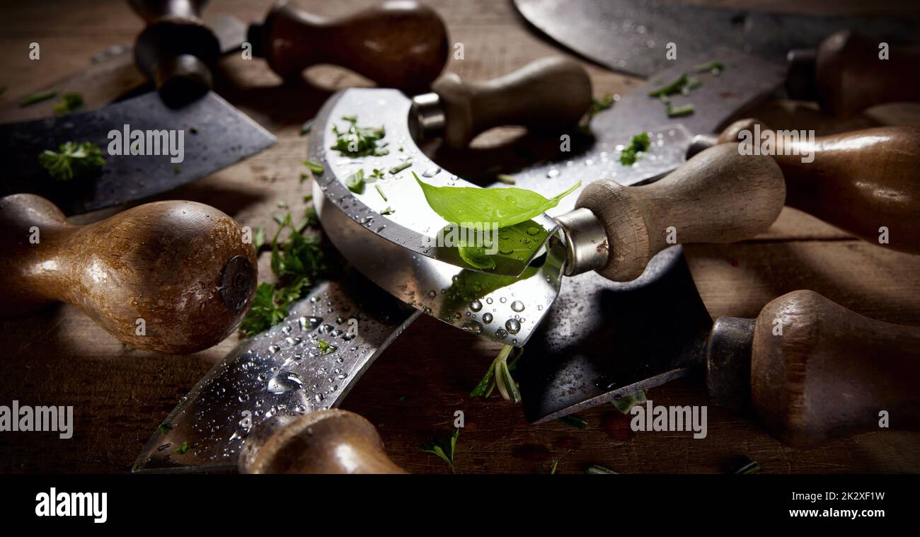 Couteaux Mezzaluna en légumes verts hachés Banque D'Images