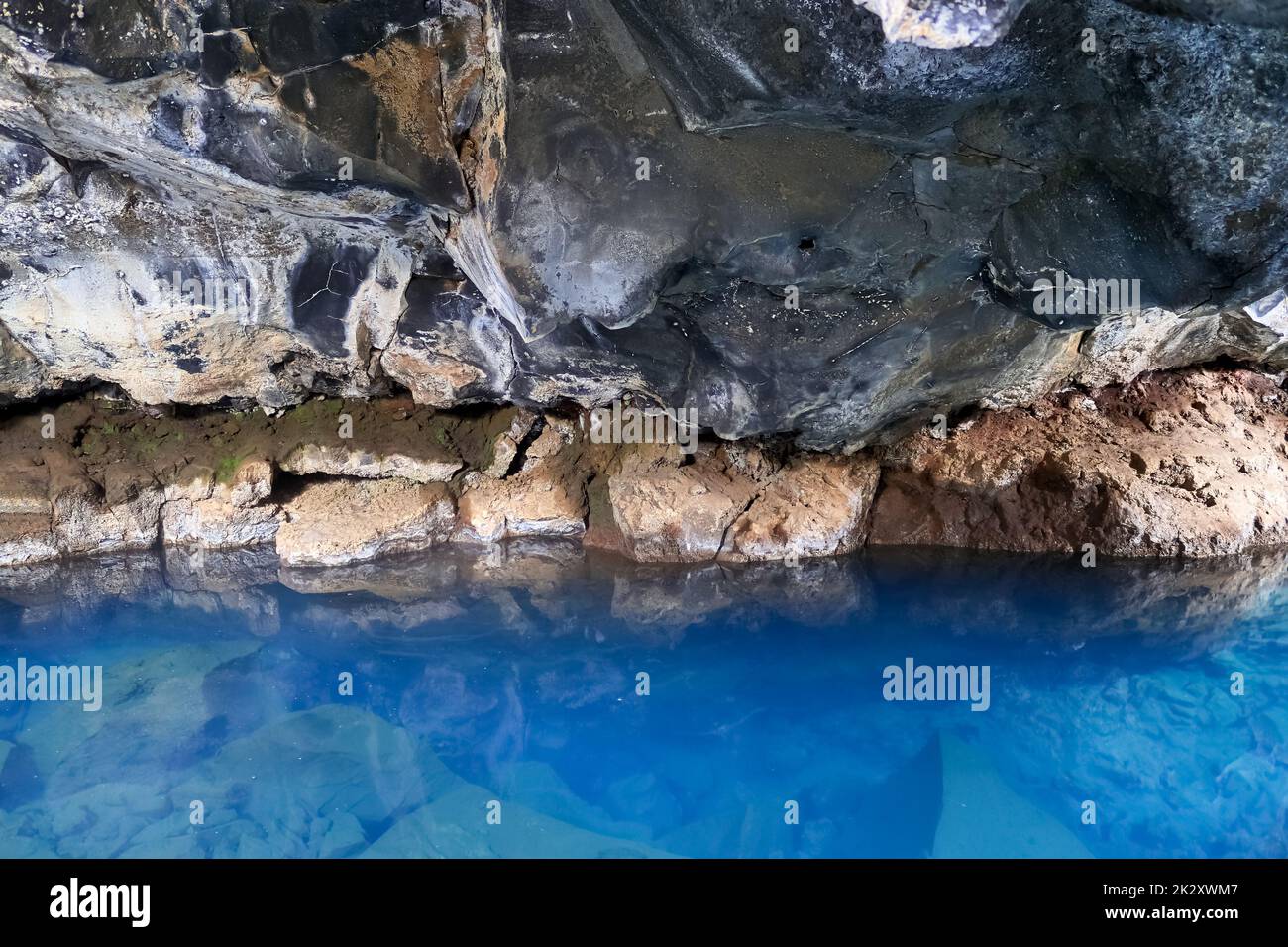 Vue sur la grotte de lave de Grjotagja avec de l'eau bleue cristalline. Banque D'Images