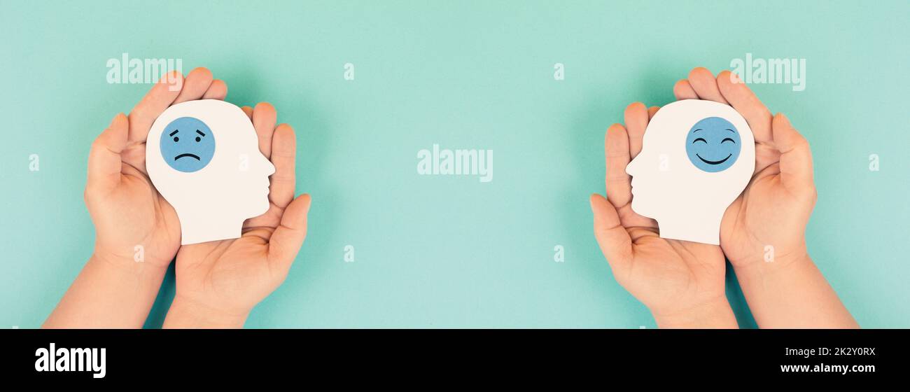 Tenir la tête avec un visage triste et heureux dans les mains, concept de santé mentale, état d'esprit positif et négatif, dépression, symbole de soutien et d'évaluation, émotion Banque D'Images
