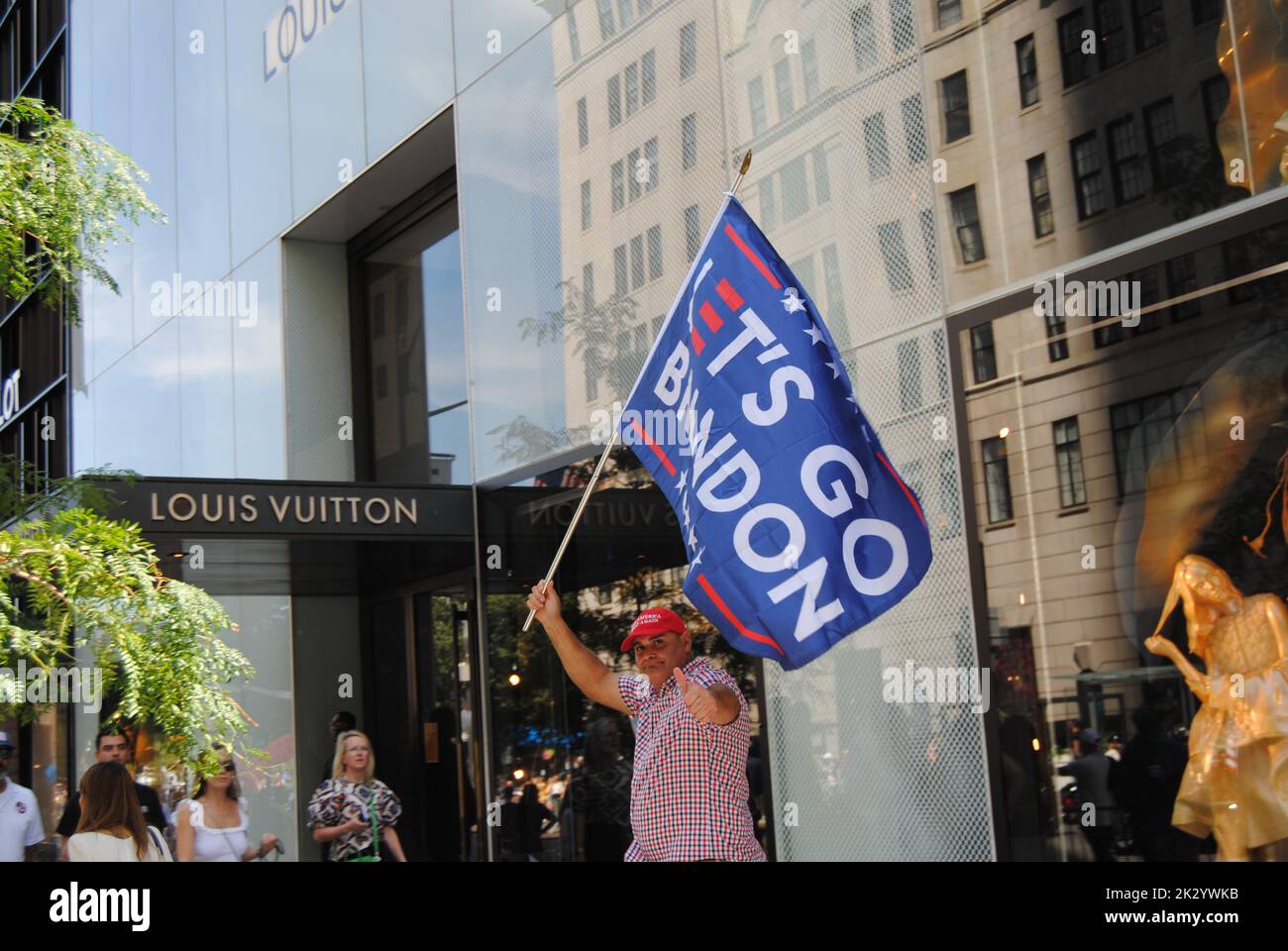 New York, New York, États-Unis - 10 septembre 2022 : un homme portant un chapeau rouge « Make America Great Again » porte un drapeau « let's Go Brandon » sur 5th Avenue. Banque D'Images