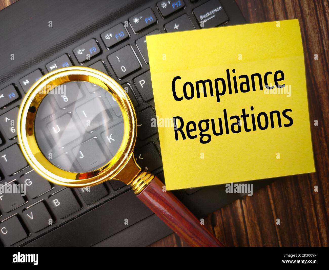 Vue de dessus de la loupe et du clavier sans fil avec le mot Compliance Regulations Banque D'Images