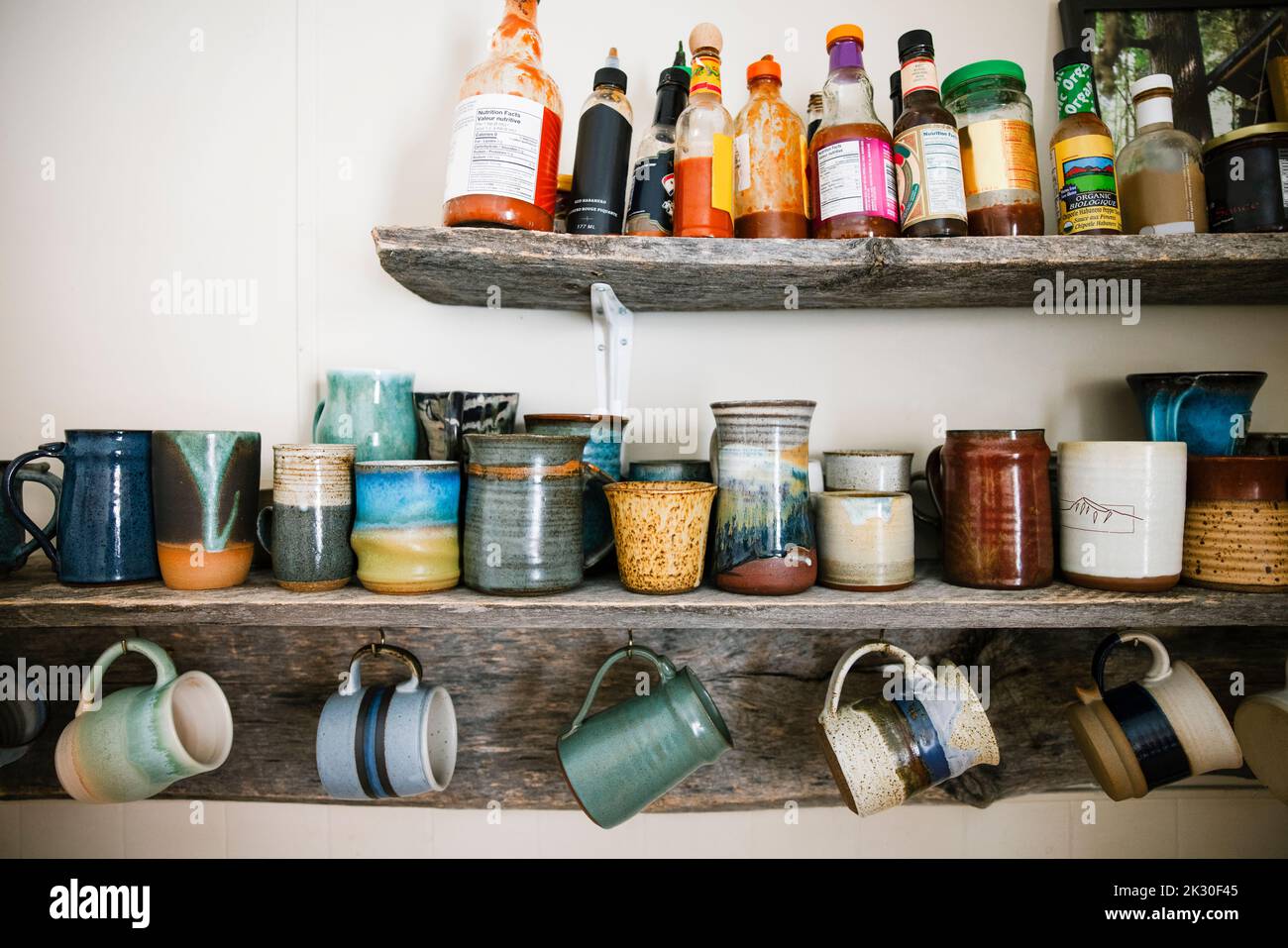 Tasses et bouteilles de sauce sur le plateau de cuisine rustique Banque D'Images
