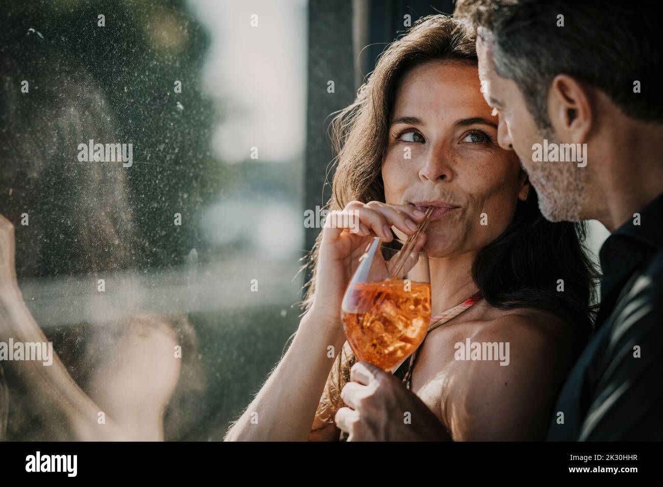 Femme ayant boire avec de la paille regardant le petit ami Banque D'Images